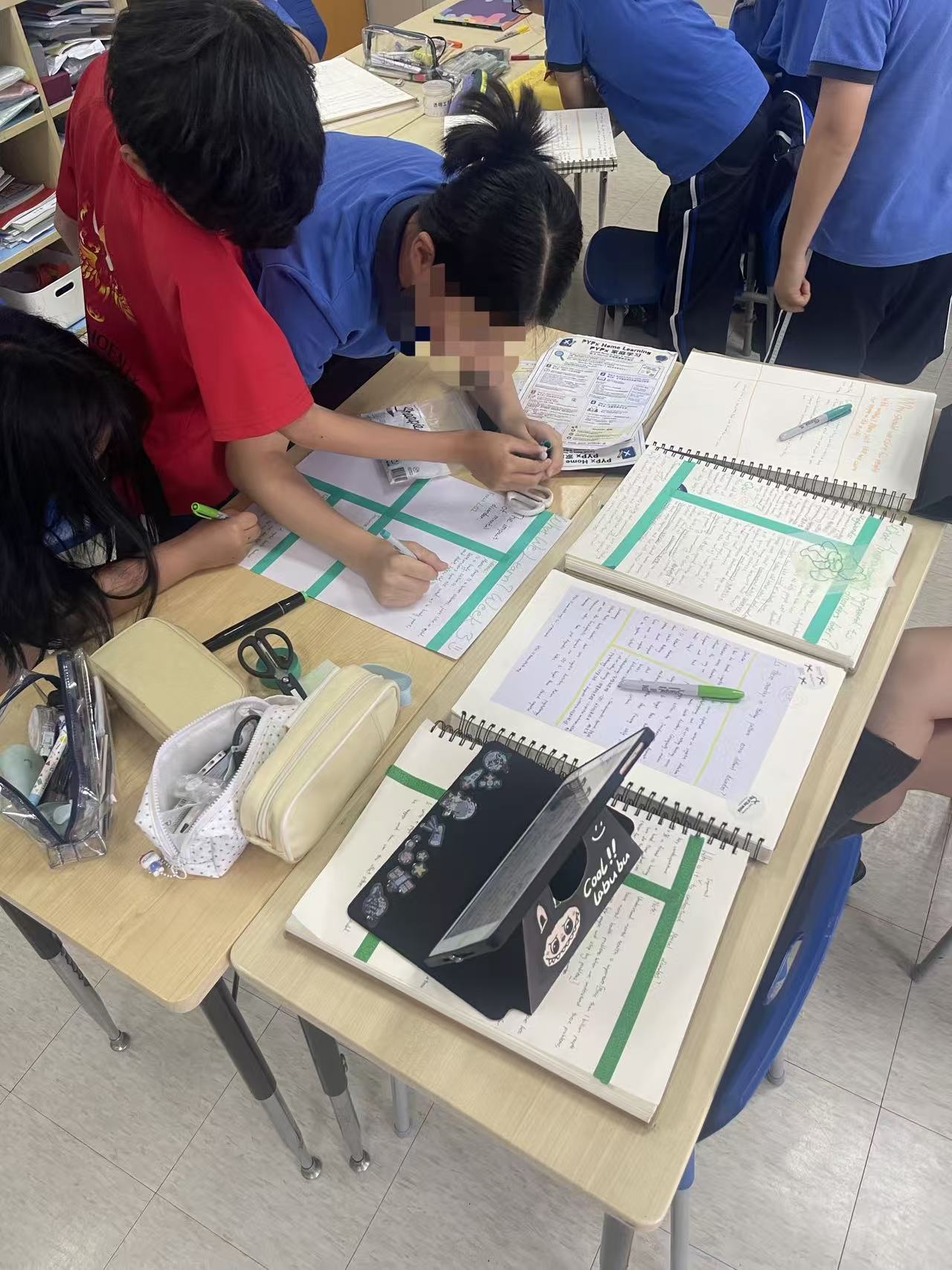 Groups building their “What We Learn? Week 3” posters from their notes and journals.