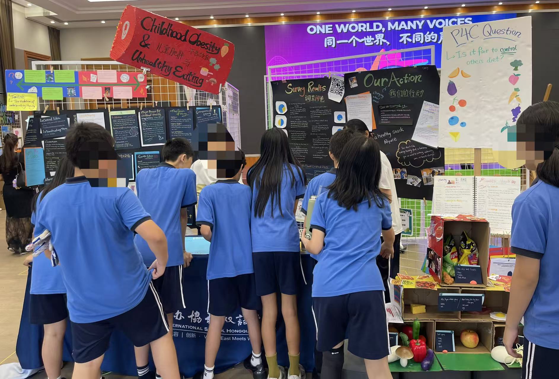 Exhibition day. The healthy eating group walks visitors through their station under the PYPx banner, central idea, action poster, and P4C question all in reach.